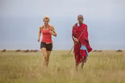 Woman jogging with a warrior at Chem Chem Lodge in Tanzania
