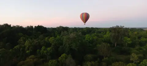 Hot air balloon soaring over the Maasai Mara in the morning